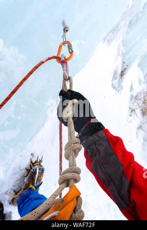 Eisklettern mit Eis Schraube, Seil, Karabiner und Kletterer arm Anker, Nahaufnahme Stockfoto