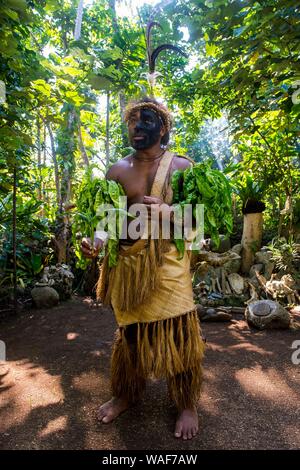 Traditionelle gekleideter Mann mit schwarzen Gesicht im Dschungel, Ekasup Cultural Village, Efate, Vanuatu Stockfoto