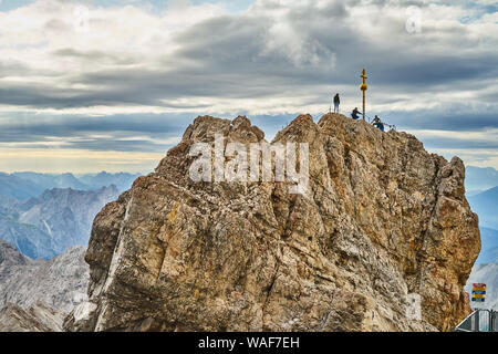 Garmisch-Partenkirchen, Deutschland, 5. August, 2019: Bergsteiger Neben dem Gipfelkreuz auf dem Gipfel der Zugspitze, dem höchsten Berg in Deutschland Stockfoto