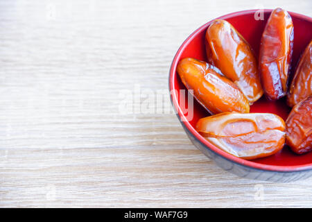 Gruppe von Phoenix Obst in rot Schüssel auf Holz- Hintergründe. Stockfoto