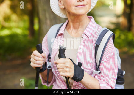 In der Nähe der reifen Frau in Freizeitkleidung Ausübung im Park im Freien tut sie Nordic Walking Stockfoto