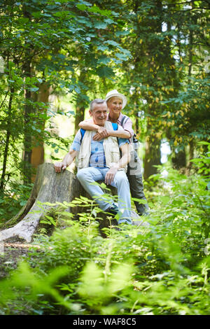 Gerne reife Frau ihren Mann umarmt, während Sie sitzen und Ausruhen nach Ihrer Wanderung in der Natur in den Wäldern Stockfoto