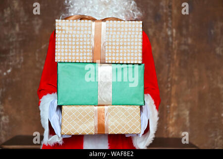 Santa Claus insgeheim anbringen Geschenkboxen unter den Weihnachtsbaum. Weihnachten Stockfoto