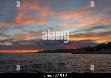 Italien. Ligurische Küste. Dramatische bunte Wolken bei Sonnenuntergang schwebt über dem Meer Stockfoto