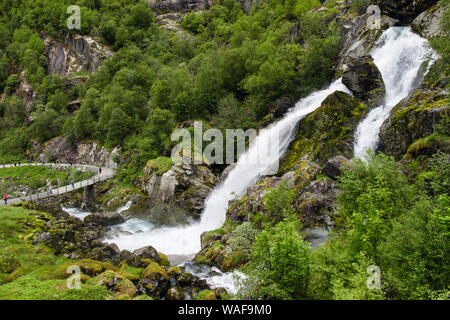 Wasserfall über den Wanderweg Route mit Touristen zu Fuß in das briksdal oder Briks Tal, Stryn, Sogn og Fjordane County, Norwegen, Skandinavien Stockfoto