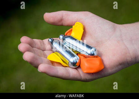 Ein Jugendlicher füllt einen Ballon mit Distickstoffoxid (Lachgas) auch als Hippie crack bekannt Stockfoto
