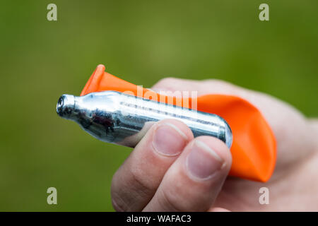 Ein Jugendlicher füllt einen Ballon mit Distickstoffoxid (Lachgas) auch als Hippie crack bekannt Stockfoto