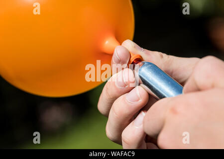 Ein Jugendlicher füllt einen Ballon mit Distickstoffoxid (Lachgas) auch als Hippie crack bekannt Stockfoto