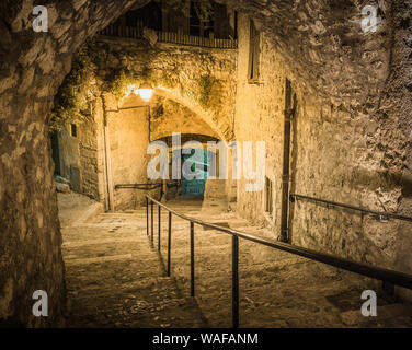 Gepflasterte Gasse in der Altstadt Peille nachts, Frankreich. Stockfoto