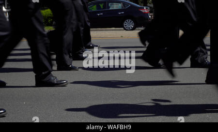 Parade Bewegung immer noch in der Nähe von einheitlichen Service Arbeitnehmer Füße marschieren gemeinsam entlang der Straße route amerikanischen Festlichkeiten mit Stolz zu feiern. Stockfoto