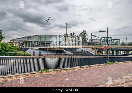 Helmond, Niederlande, 16. August 2019: eine Brücke für Fahrräder und Fußgänger kreuzen einer verkehrsreichen Straße in der Station Square, mit der neuen Bahn Stati Stockfoto