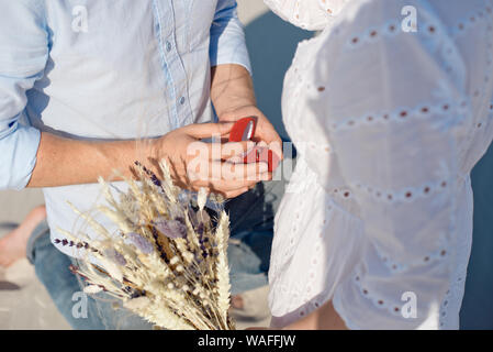 Schöner Mann macht Heiratsantrag zu Mädchen Sanddünen. Stockfoto