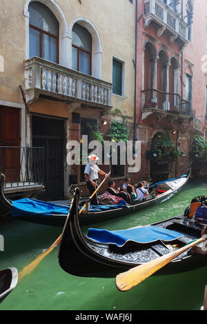 Venedig, Italien - Oktober 06, 2012: Touristen Fahrt in einer Gondel in einem Seitenkanal Stockfoto