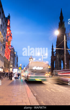 Abstraktes Bild der Verkehr in der Nacht in der Princes Street Edinburgh Schottland Großbritannien. bei Nacht mit unscharfen Fahrzeuge, Verkehr und die Leute