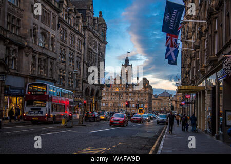 Moody street scene auf der Royal Mile in Edinburgh Schottland Großbritannien, Hotel Hilton, alte Gebäude, Geschäfte, Autos, Busse und Menschen plus Flags Stockfoto