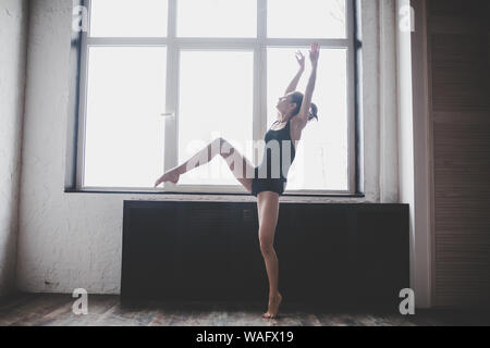 Plastizität schlanke Frau tanzen neben Fenster. Professionelle Tänzer genießen Tanz. Lady Dancer Training Modern Ballet In Class. Zeitgenössischer Tanzkünstler Stockfoto