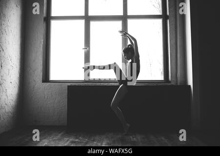 Plastizität schlanke Frau tanzen neben Fenster. Professionelle Tänzer genießen Tanz. Lady Dancer Training Modern Ballet In Class. Zeitgenössischer Tanzkünstler Stockfoto