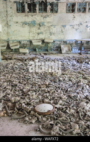 Sperrzone von Tschernobyl - Pripyat - Schule Nummer 3 - Gasmasken und Uhr alle auf den Boden fallen gelassen. Stockfoto