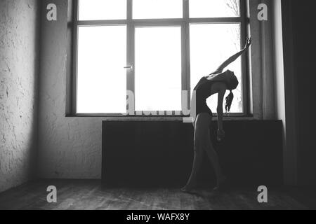 Plastizität schlanke Frau tanzen neben Fenster. Professionelle Tänzer genießen Tanz. Lady Dancer Training Modern Ballet In Class. Zeitgenössischer Tanzkünstler Stockfoto