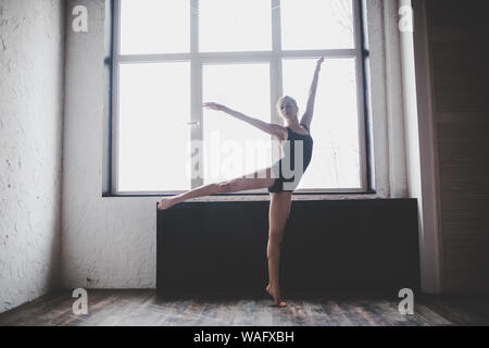 Plastizität schlanke Frau tanzen neben Fenster. Professionelle Tänzer genießen Tanz. Lady Dancer Training Modern Ballet In Class. Zeitgenössischer Tanzkünstler Stockfoto