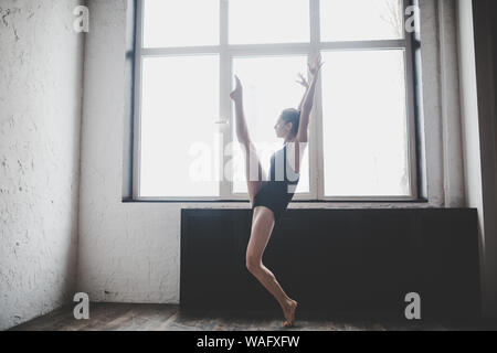 Plastizität schlanke Frau tanzen neben Fenster. Professionelle Tänzer genießen Tanz. Lady Dancer Training Modern Ballet In Class. Zeitgenössischer Tanzkünstler Stockfoto