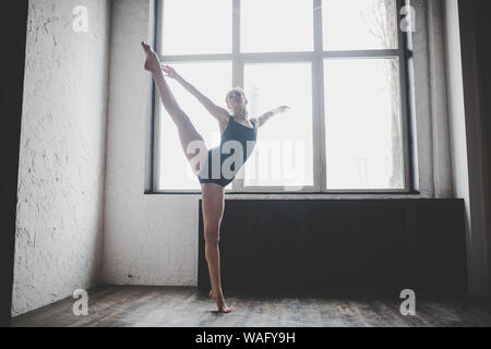 Plastizität schlanke Frau tanzen neben Fenster. Professionelle Tänzer genießen Tanz. Lady Dancer Training Modern Ballet In Class. Zeitgenössischer Tanzkünstler Stockfoto