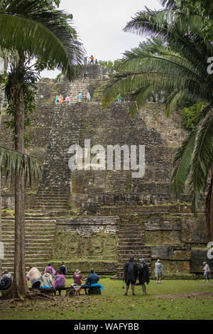 LAMANAI, Belize - Januar 15, 2018: Touristen beobachten und auf der Maya Tempel von Lamanai in Belize zu klettern. Stockfoto