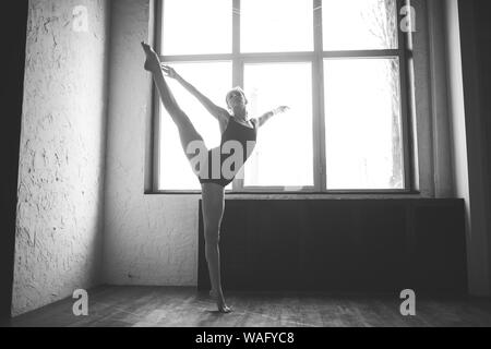 Plastizität schlanke Frau tanzen neben Fenster. Professionelle Tänzer genießen Tanz. Lady Dancer Training Modern Ballet In Class. Zeitgenössischer Tanzkünstler Stockfoto