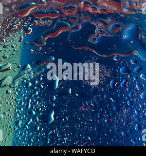 Neon Wasser dropletss von lila und blau gefärbten Hintergrund. Trendige Kulisse für Ihr Design. Stockfoto