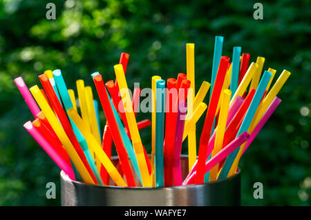 Viele verschiedene bunte Strohhalme gegen einen dunklen Hintergrund Stockfoto