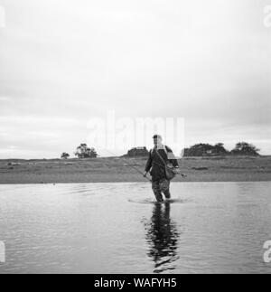 Mann beim Angeln nahe der Stadt Punta Arenas, im Süden von Chile, 1957. Mann angeln in der Nähe von Punta Arenas, im Süden Chiles, 1957. Stockfoto