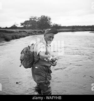 Mann beim Angeln nahe der Stadt Punta Arenas, im Süden von Chile, 1957. Mann angeln in der Nähe von Punta Arenas, im Süden Chiles, 1957. Stockfoto