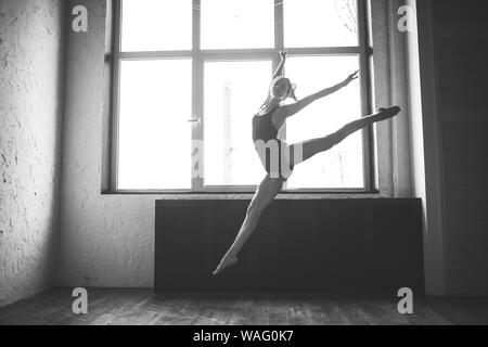 Plastizität schlanke Frau tanzen neben Fenster. Professionelle Tänzer genießen Tanz. Lady Dancer Training Modern Ballet In Class. Zeitgenössischer Tanzkünstler Stockfoto