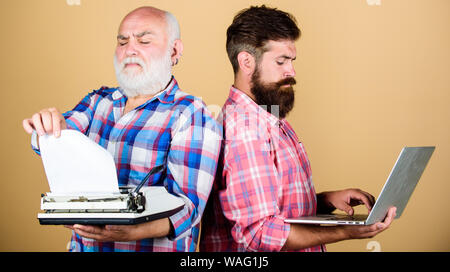 Vater und Sohn. Technologie Entwicklung und Verbesserung. Technologie generation kämpfen. Das moderne Leben. retro Schreibmaschine laptop vs. Jugend vs Alter. business Ansatz. Zwei bärtigen Männern. Vintage Schreibmaschine. Stockfoto