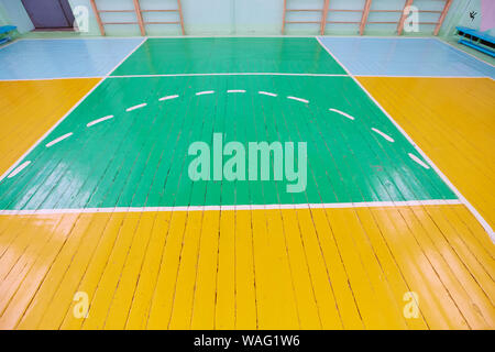 Alte Risse im Boden der Sporthalle mit Markierungen für Basketball. Stockfoto