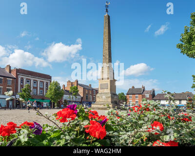 Obelisk auf dem Markt mit Sommerblumen im Vordergrund Ripon North Yorkshire England Stockfoto