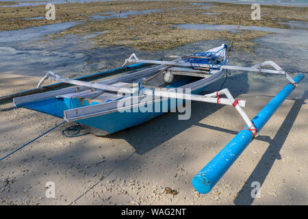 Ein Boot am Ufer auf Gili Meno, Lombok, Indonesien geparkt. Kleines Fischerboot parkte und am Strand bei Ebbe vertäut. Schiff und Anker an der Stockfoto