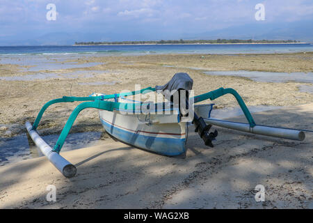 Ein Boot am Ufer auf Gili Meno, Lombok, Indonesien geparkt. Kleines Fischerboot parkte und am Strand bei Ebbe vertäut. Schiff und Anker an der Stockfoto