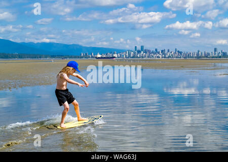 Die jungen langhaarigen Jungen skimboarding, Spanische Banken, English Bay, Vancouver, British Columbia, Kanada Stockfoto