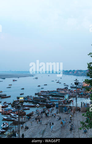 Boote mit Touristen auf dem Wasser des Ganges in der Nähe Ghat bei Dämmerung Stockfoto