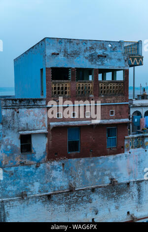 Verwitterte alte Haus auf verschmutzte Ufer des Ganges in Varanasi in der Dämmerung Stockfoto