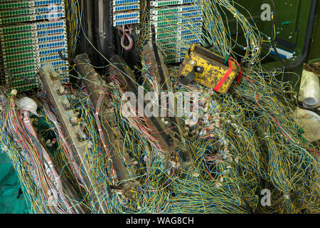 Verworrene Masse von verdrillten Telefonleitungen in einem Netzwerk auf öffentlichen Fußweg repariert wird, präsentiert ein echtes Rätsel, Links auf Kaffee Pause Stockfoto
