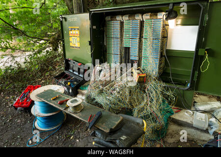 Verworrene Masse von verdrillten Telefonleitungen in einem Netzwerk auf öffentlichen Fußweg repariert wird, präsentiert ein echtes Rätsel, Links auf Kaffee Pause Stockfoto