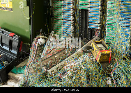 Verworrene Masse von verdrillten Telefonleitungen in einem Netzwerk auf öffentlichen Fußweg repariert wird, präsentiert ein echtes Rätsel, Links auf Kaffee Pause Stockfoto