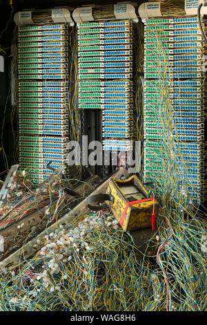 Verworrene Masse von verdrillten Telefonleitungen in einem Netzwerk auf öffentlichen Fußweg repariert wird, präsentiert ein echtes Rätsel, Links auf Kaffee Pause Stockfoto