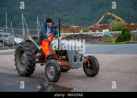 Mann, der 1957 Vintage Massey Ferguson FE 35 Gold Bauch Grey Fergie Traktor vorne abseits Treiber Seitenansicht männlichen orange wasserdichte Hosen veteran H Stockfoto