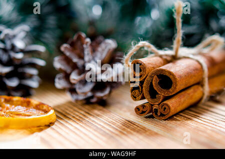 Weihnachtskarte: Zimt und einer Scheibe Zitrone liegt auf einem braunen Holz- hintergrund Neben der Tannenzapfen Stockfoto