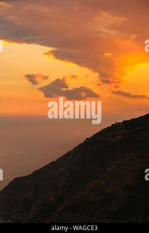 Blick in den Himmel, während eine schöne orange Sonnenuntergang mit Wolken über die Berge. Stockfoto
