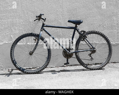 Schwarz altes Fahrrad, Mountainbike neben einer weißen Wand Stockfoto