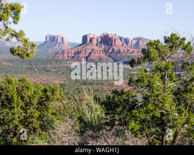 Sedona vorstädte am späten Nachmittag aus der Ferne gesehen. Red Rock Landschaft von grünen Bäumen im Vordergrund gerahmt Stockfoto